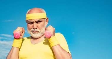 Antrenmandan sonra yaşlı bir adam. Yaşlılar için sağlık kulübü ya da rehabilitasyon merkezi. Spor merkezinde yaşlı sporcu dambılları kaldırıyor..