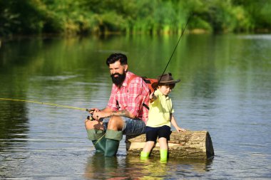 Nesiller boyu: baba ve oğul. Aile tatili ve birliktelik. Nehirde balık tutmak. Yaşlı ve Genç. Baba ve oğul birlikte dinleniyorlar..