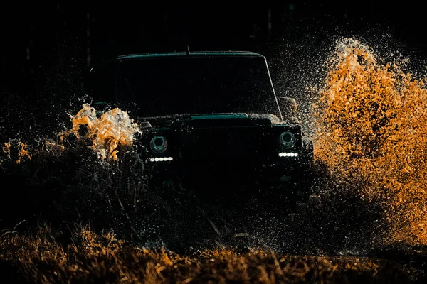 Jeep aventuras al aire libre. Neumáticos en preparación para la carrera. Huellas en un campo fangoso. Aventura por carretera. Viaje de aventura. Rally de carreras. Salpicaduras de barro y agua en las carreras off-road . — Foto de Stock