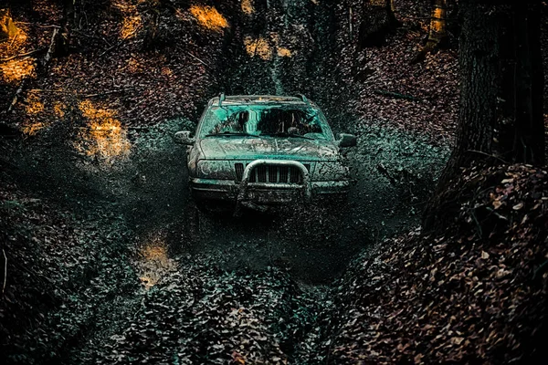 Straßenabenteuer. Abenteuerreisen. Geländewagen, der aus einem Schlammloch kommt. 4x4 Reisetrekking. Schlamm und Wasser beim Geländerennen. — Stockfoto