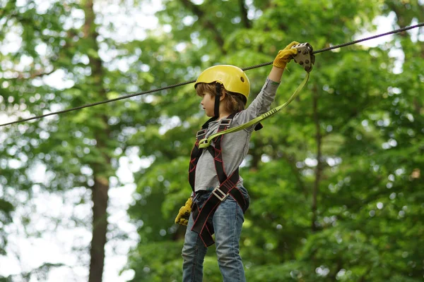 Go Ape Adventure. Adventure climbing high wire park. Child. Happy child boy calling while climbing high tree and ropes. Every childhood matters. Balance beam and rope bridges. — Stock Photo, Image