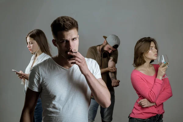 Four people displaying addiction to alcohol, nicotine, drugs and gadgets. Epidemic, addiction pandemic. Set of bad habit and addiction. — Stock Photo, Image