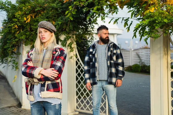 Autumn depression. Bad mood without reason. Frustrated confused woman in warm clothing is feeling unhappy. Disappointed guy on the background.