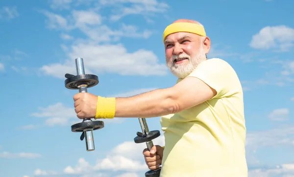 Concetto di pensione. Nonno che si allena con i manubri. Sport per uomo anziano . — Foto Stock