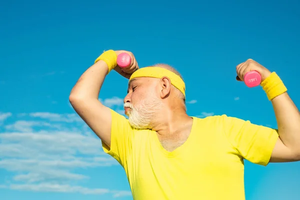 Come lo sport e i muscoli. Uomo muscoloso anziano dello sport. Uomo anziano praticare sport su sfondo cielo blu . — Foto Stock