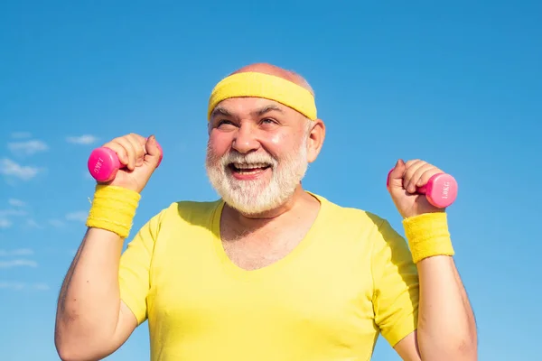 Maschio anziano sta godendo stile di vita sportivo. Buon uomo anziano che si allena con il sollevamento di manubri all'aperto. Uomo anziano dopo il suo allenamento . — Foto Stock