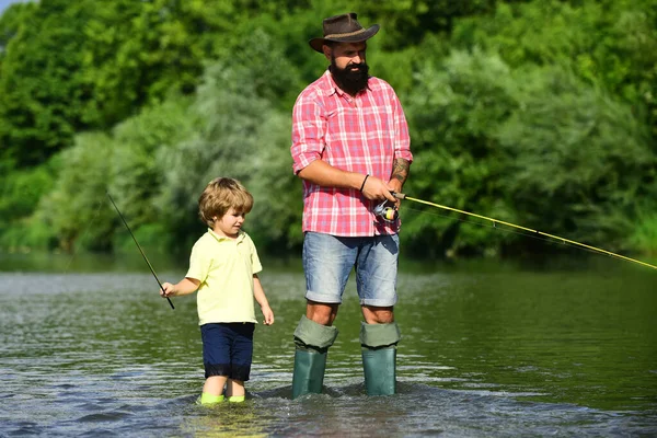 Vater und Sohn angeln und entspannen beim Hobby. Angler. Fischer Vater und Sohn angeln mit Angelrute in einem Fluss. — Stockfoto