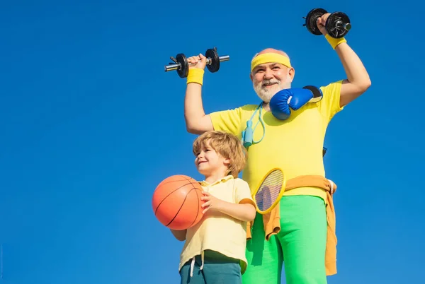 Family time together. Follow grandfather. Sports coach with dumbbells and kid with basketball ball.