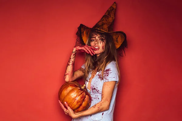 Wiedźma z dynią. Piękno Halloween kobieta na czerwonym tle odizolowany. Agresywna dziewczyna we krwi. Cholerny bałagan.. — Zdjęcie stockowe