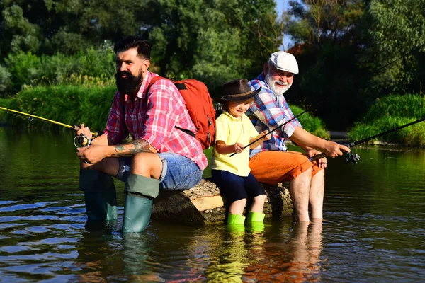 Father, son and grandfather fishing. Men day. Great-grandfather and great-grandson. Fly fishing for trout. Father and son fishing.