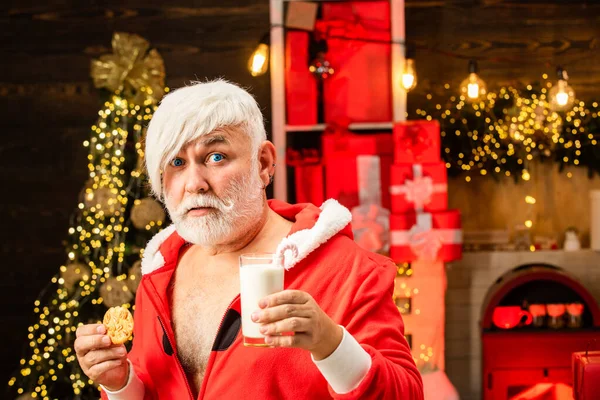 Porträt des überraschten und lustigen Weihnachtsmannes. happy santa claus - mit einem Glas Milch und Keksen. Porträt des Weihnachtsmannes mit Schokoladenkeks und einem Glas Milch. — Stockfoto