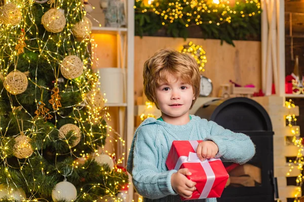 新年の子供たち。メリークリスマスとハッピーホリデー。クリスマスプレゼントを持っている面白い子供。クリスマス前の朝だ。クリスマスの子供たち-幸福の概念. — ストック写真