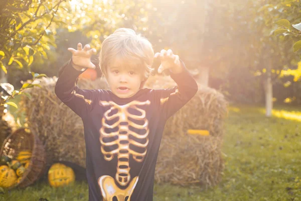 Szkieletowe dziecko Halloween. Halloween przyjęcie kostiumowe dla dzieci. Szczęśliwe śmiejące się dziecko w kostiumie na Halloween. Zabawny dzieciak w strojach karnawałowych.. — Zdjęcie stockowe