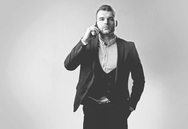 Akıllı telefon kullanan adam. Telefon mobil ile çalışan iş adamı. Lüks klasik takım elbiseler, moda. Toplantı telefonu. Erkek takım elbise moda.