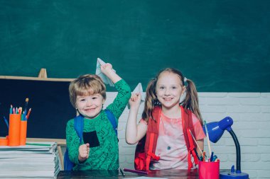 Okula geri dön. Çocuklar okul için hazırlanıyor. Komik küçük çocuk tahta arka plan üzerinde eğleniyor. Öğretmenler günü.