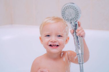 Şirin Bebek Banyoda saç yıkıyor. Sağlık ve günlük rutin için kavram. Bebek duş aldıktan sonra bir havlu ile. Çocuk banyo.