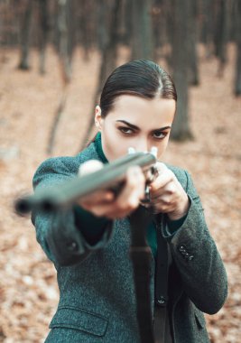 Silahlı bir kadın. Bir avcı av av silah ve av formu ile. Avcı kadın. Bir sırt çantası ve bir av silahı ile avcı.