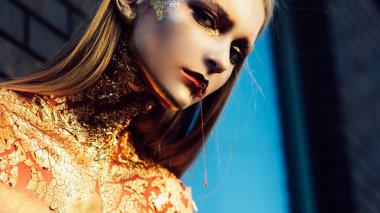 Altın Cadı. Cadılar Bayramı parti sanat tasarımı. Cadılar Bayramı tasarımı. Altın saç stili ve Cadılar Bayramı için makyaj. Cadılar Bayramı Cadı Kız portresi Altın makyajlı.