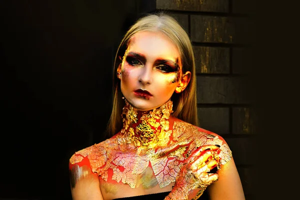 할로윈 파티 여자 애 야. 아름다운 황금 눈붉은 입술. ( 영어 ) art gold skin girl face - Halloween portrait close-close. 메탈 얼핏 보기 패션 초상화. 할로윈을 위한 황금 여성의 피부. — 스톡 사진