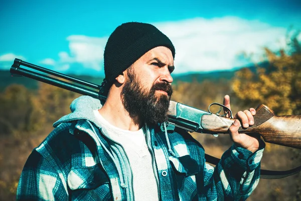 Hunter mannen. Jakt under höstsäsongen. Jägare med jakt pistol och jakt form att jaga i skogen. Jägare med en ryggsäck och en jakt pistol. Man innehav hagelgevär. — Stockfoto