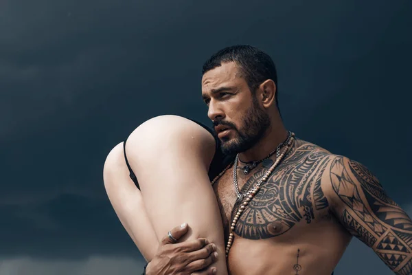 Tattoo salon. Tattooed latinos - sexual concept. Passionate lover caressing arousing beautiful woman. Sensual woman with handsome man.