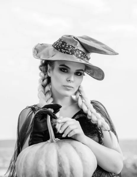 Mujer posando con Calabaza. Bruja de Halloween con sombrero mágico. Hermosa joven sorprendida mujer en sombrero de brujas y traje de calabaza celebración. Muchacha modelo atractiva en disfraz de Halloween . —  Fotos de Stock