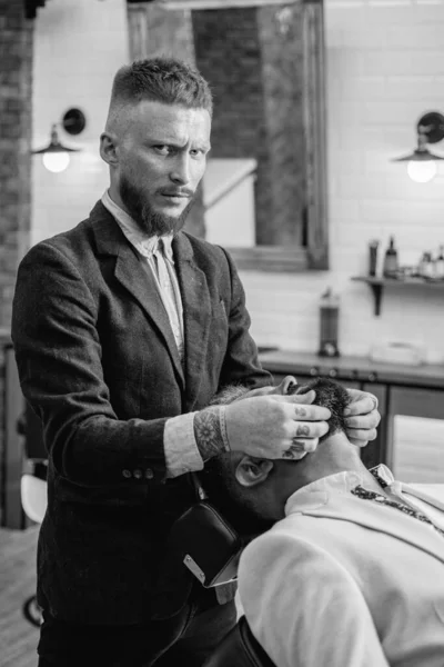 Peluquero profesional en barbería interior. Hombre mayor visitando peluquero en la peluquería. Barber - Shaves and Trims (en inglés). Estilo de cabello y estilista . — Foto de Stock