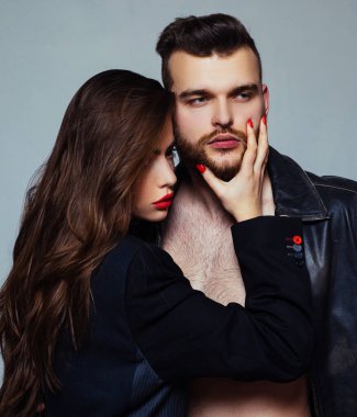 She adores male brutal beard. Passionate hug. Couple passionate people in love. Man brutal well groomed macho and attractive girl cuddling. Girlfriend passionate red lips and man leather jacket clipart