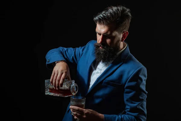 Hipster z brodą i wąsami w garniturze pije alkohol po dniu pracy. Sommelier smakuje drogo.. — Zdjęcie stockowe