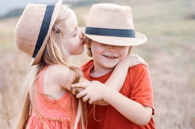 Çocuklar mavi gökyüzü arka planına karşı yeşil alanda eğleniyorlar. - Valentine. Çocukluk konsepti. Tatlı çocukluk. Melek karakterli bir çocuk. Kırsalda yaz.