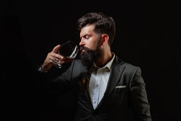 Stylowy mężczyzna z brodą Barman trzyma szklankę whisky. Sommelier smakuje drogo.. — Zdjęcie stockowe