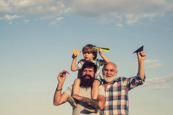 Mutlu erkek ailesi birlikte eğleniyor. Hafta sonu aile oyunu. Babalar Günü - Büyükbaba, baba ve oğul kucaklaşıyor ve birlikte eğleniyorlar.. — Stok fotoğraf