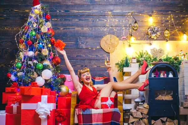 Gelukkige vrouw met kerstcadeau over kerst interieur achtergrond. Schoonheid Kerst mode model meisje holding xmas gift box. — Stockfoto