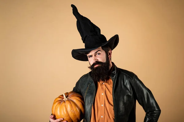 stock image Halloween man with pumpkin - Holidays celebration concept. Happy Halloween. Halloween Man posing with pumpkins. Young man with witch hat ready to Halloween party.