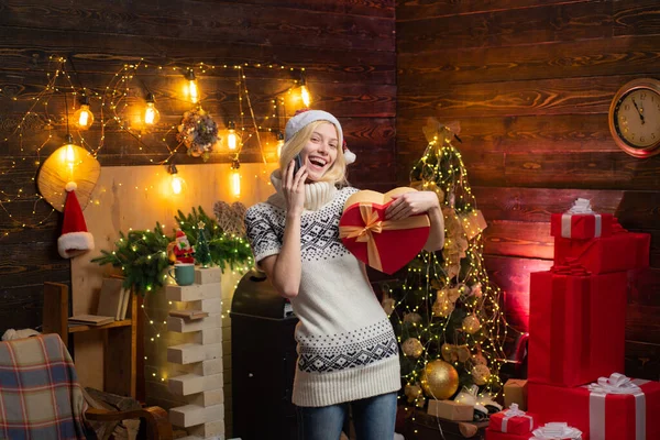 Fille vêtements d'hiver santa claus chapeau célébrer Noël et bonne année. Noël arrive. Accueil décoration d'arbre de Noël intérieur. Femme pull tricoté confortable profiter de l'atmosphère de Noël à la maison — Photo