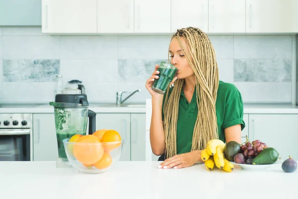 Mujer bebiendo espirulina verde en una cocina blanca. Alimentación vegana en casa. Peso ideal y pérdida de peso. Tendencia de la dieta vegetariana. Comer y comida saludable. Estilo de vida saludable . — Foto de Stock