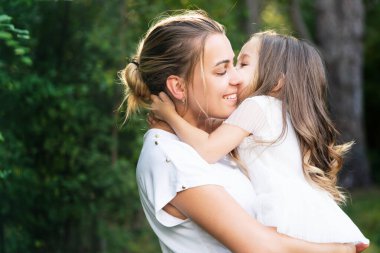 Aile kavramını kucakla ve kucakla. Anne ve çocuk sevgisi. Anne-kız kucaklaşması. Mutlu aile ve güzel anne-kız birlikte vakit geçiriyorlar. Anneler Günü. Aile ve annelik kavramı.