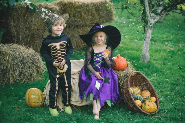 Boldog Halloweent! A gyermekbarátság, a béke, a kedvesség, a gyermekkor fogalma. Halloween gyerekek élvezik az őszi parkban a pályán. — Stock Fotó