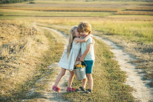 Sommerfreizeit. glückliches Kind auf dem Sommerfeld. niedlichen kleinen Bauern - Schwester und Bruder arbeiten mit spud auf dem Frühlingsfeld. Landwirtschaft und landwirtschaftlicher Anbau. zwei Junglandwirte. — Stockfoto