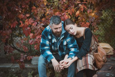 Attractive couple having a romantic moment together, dressing in traditional rural style sitting close to each other on an autumn day. The concept of genuine emotions. Meeting and accompany your