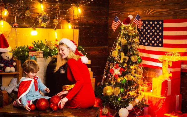 Happy mother and son celebrating New Year together. Mum with her little baby boy decorate sweet home at Christmas eve. Portrait of happy mother and adorable baby celebrate Christmas. — Zdjęcie stockowe