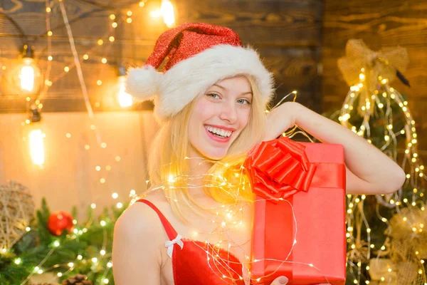 Mooie sexy blonde nieuwjaar jonge vrouw in kerstmis santa rode hoed met bont in korset met geschenkdoos. Vrolijk kerstfeest. Helder nieuwjaar interieur. Vrolijk kerstfeest en gelukkig nieuwjaar. — Stockfoto