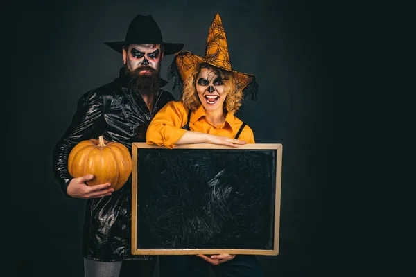 Felice coppia gotica in costume di Halloween. Jack-o-lanterne. Manifesto di Halloween o biglietto di auguri - concetto di persone . — Foto Stock