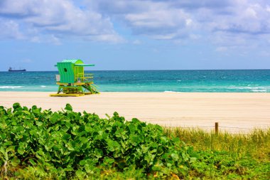 Miami sahilinde güneşli bir gün. Cankurtaran kulesi ve renkli bulutlu ve mavi gökyüzü olan Miami Plajı..