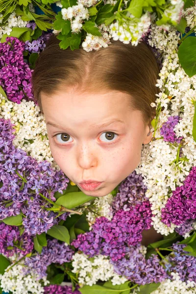 Spring funny girl outdoors portrait in blooming trees. Teenager girl with bouquet of purple and white lilac. — Stock Photo, Image