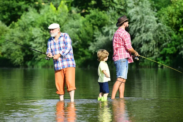 何世代も。祖父と父と息子は川でフライフィッシングをしている. — ストック写真