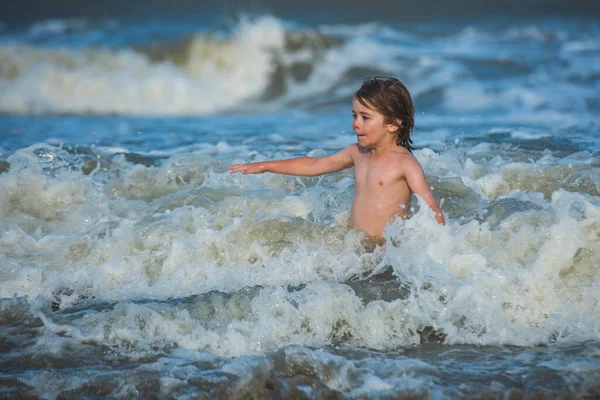 Dzieciak bawiący się na plaży w letnie wakacje. Dzieci skaczące w pobliżu fal. Wakacje na tropikalnej wyspie. — Zdjęcie stockowe