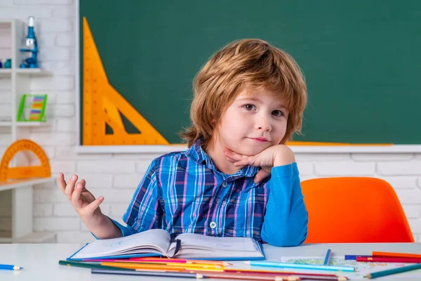 Schüler gegen grüne Tafel. Kind macht sich bereit für die Schule. Niedliche Vorschule im Klassenzimmer. — Stockfoto