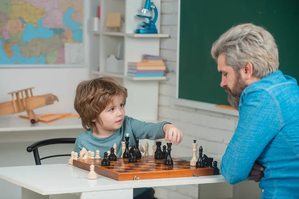 Chess success and winning. Family relationship with son. Cute boy developing chess strategy. Concept of education and teaching. Educational games.