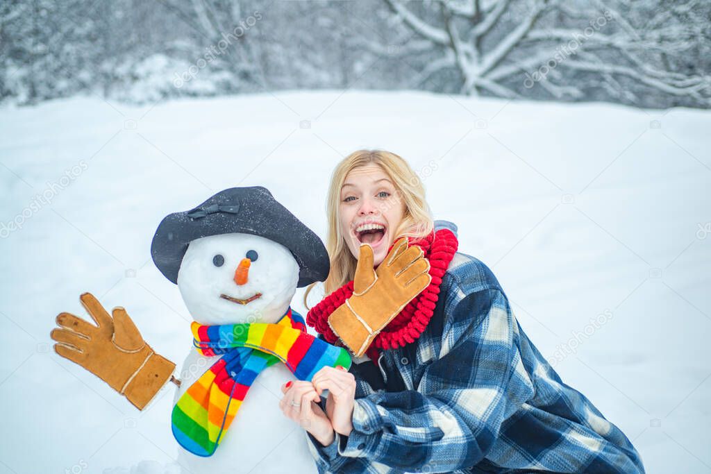 Hipster Girls playing with Snowman on snow Winter landscape.